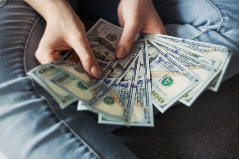 manos contando billetes de dólar representando el hábito de ahorrar dinero cada semana