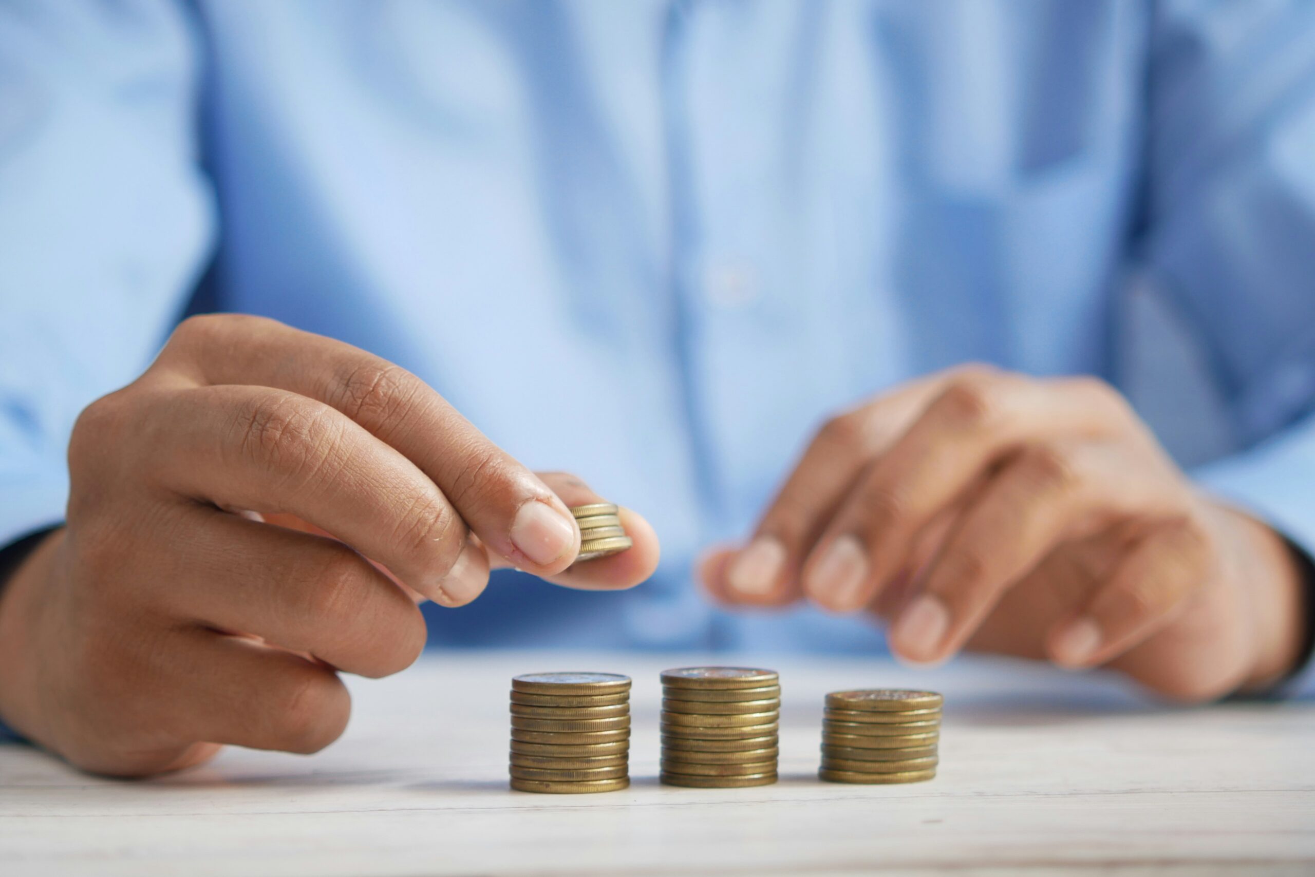 manos apilando monedas representando cómo empezar a invertir desde cero en México